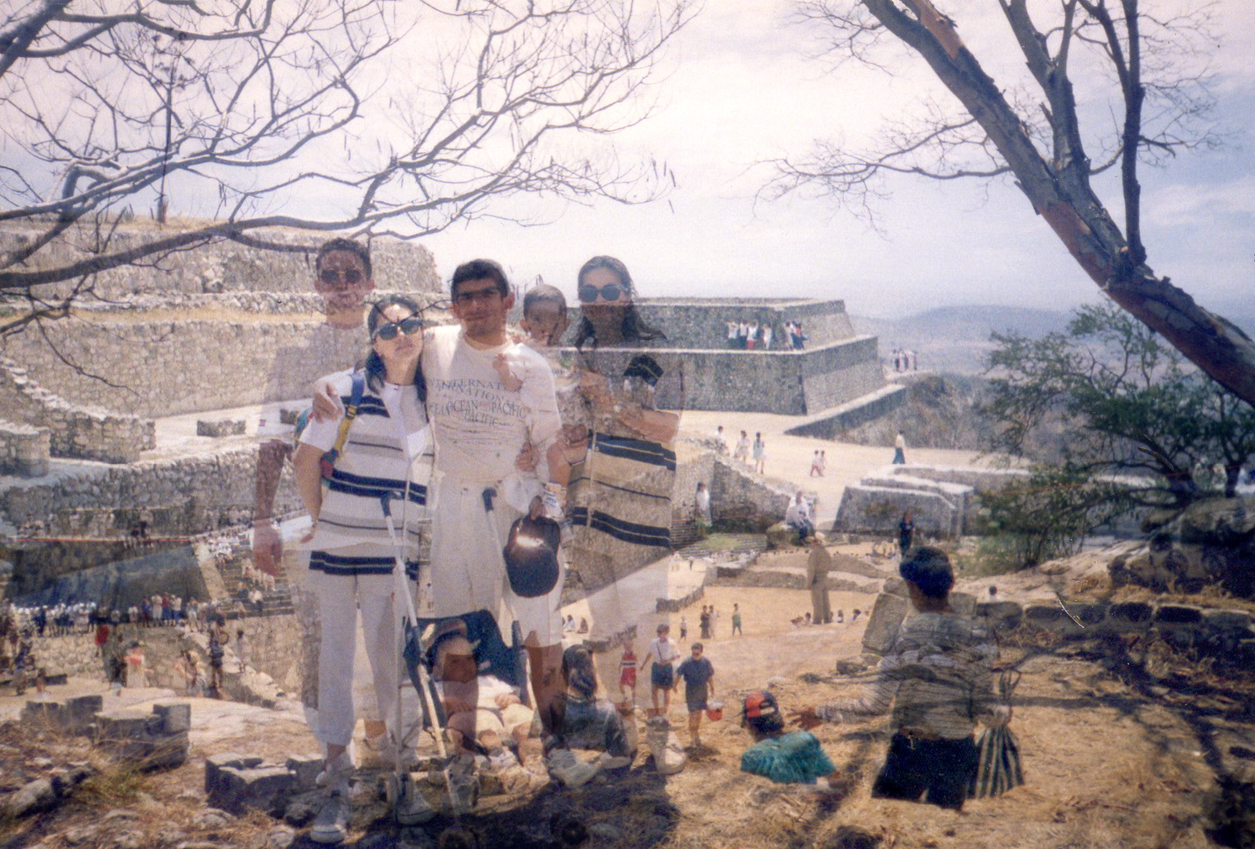 Turistas visitando un sitio arqueológico maya con estructuras escalonadas de piedra.